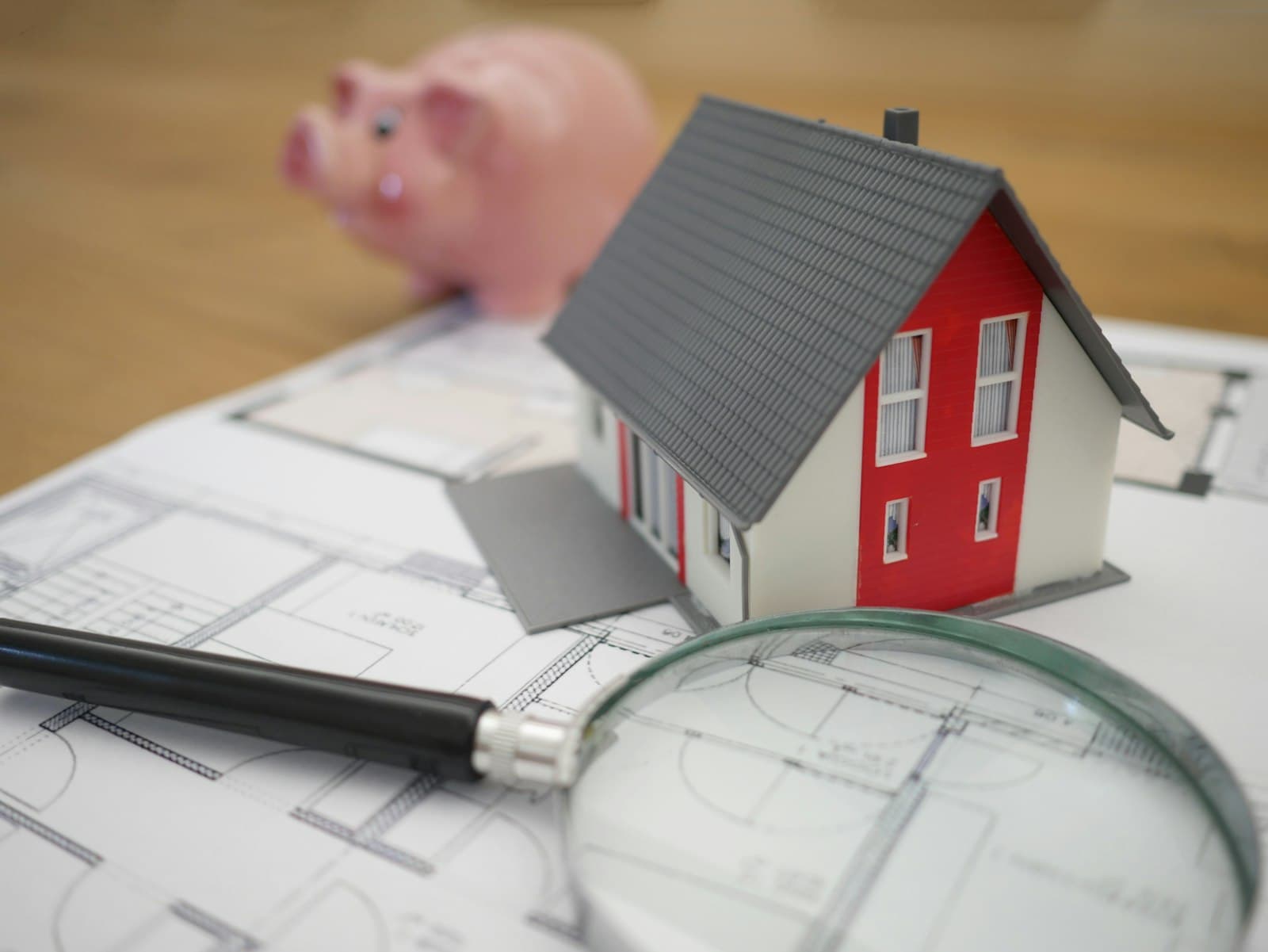 Maqueta de casa, hucha y plano de vivienda